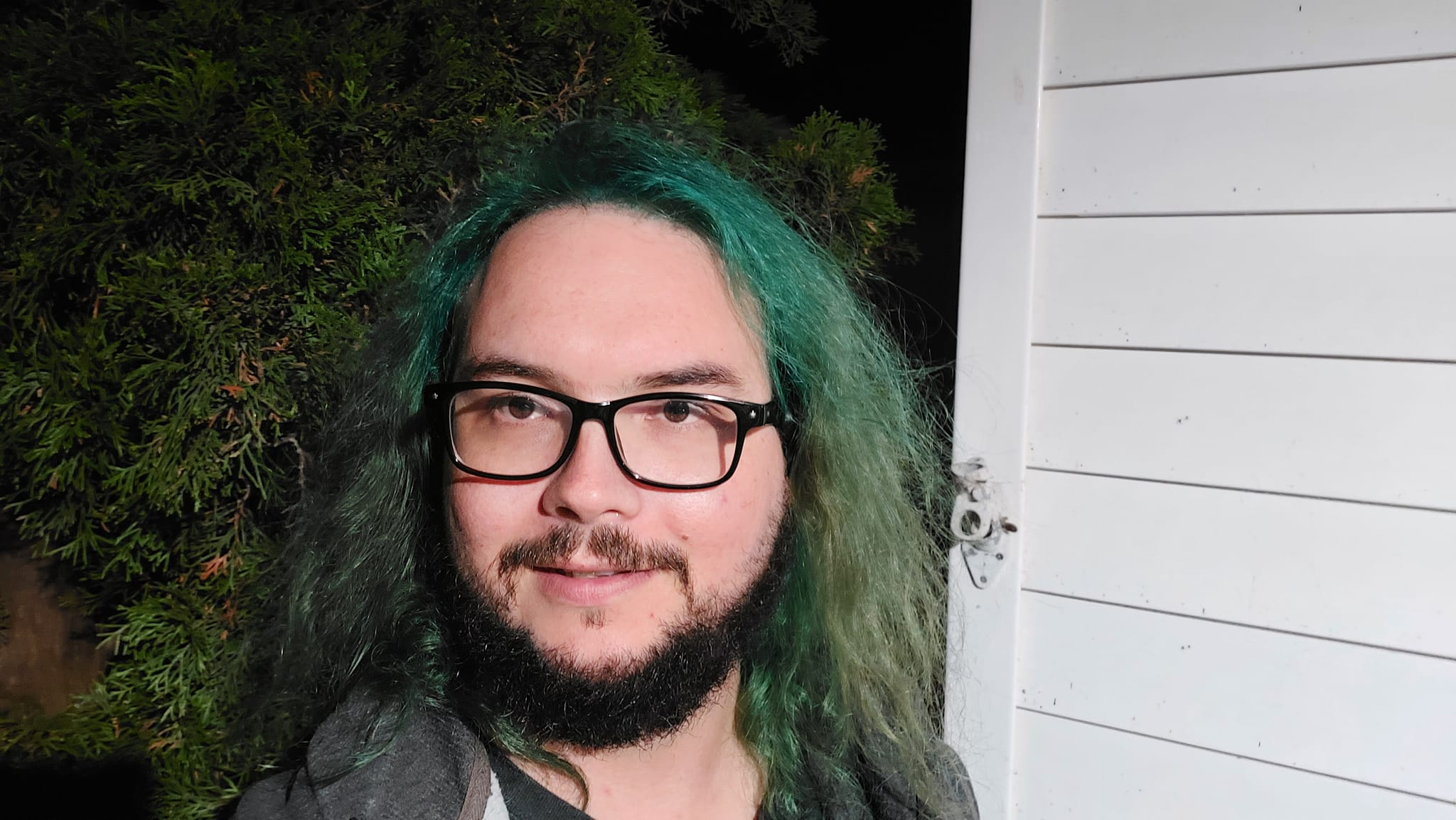 A man with green hair is outside after dark, Photo 9